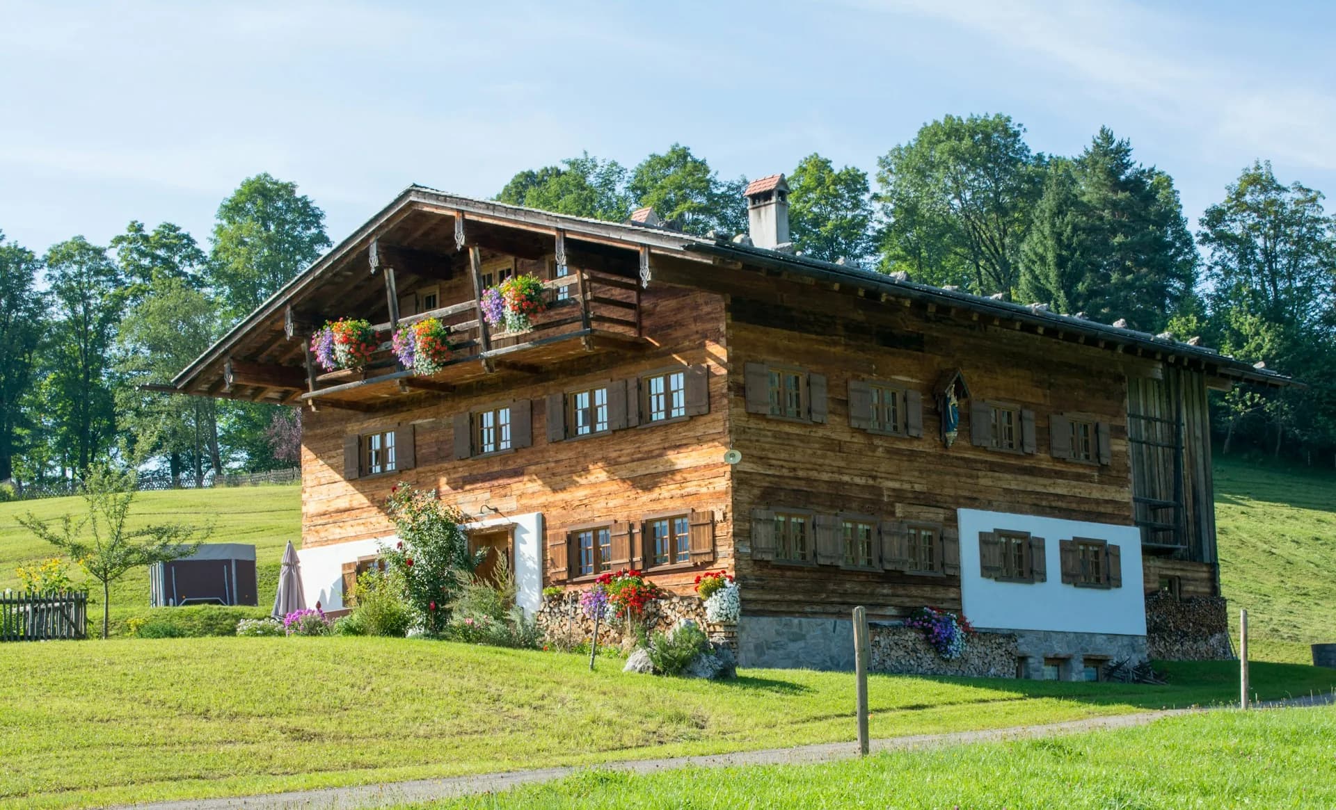 Chalet savoyard traditionnel et ses balcons fleuris en été